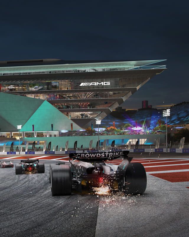 Race cars at night with sparks flying and a lit-up AMG building in the background.